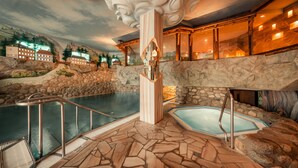 A spa area with a pool, stone walls, and a scenic mural. - Sendlhofer's (Bad Hofgastein)