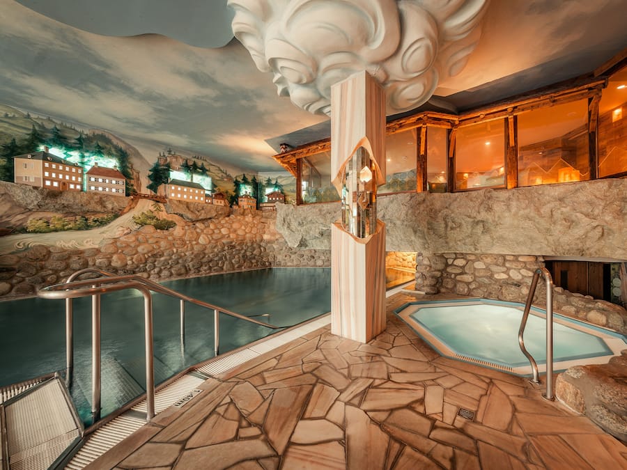 Una piscina cubierta, una piscina al aire libre, sombrillas, tumbonas