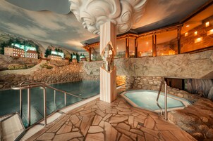 Una piscina techada, una piscina al aire libre, sombrillas