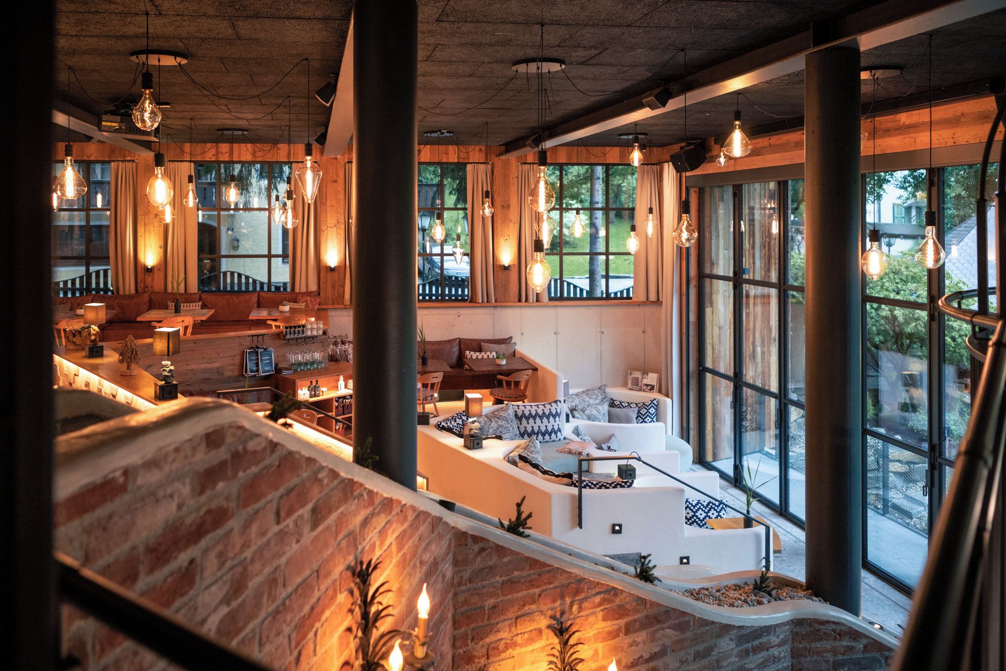 A modern interior with a fireplace, seating area, and large windows.