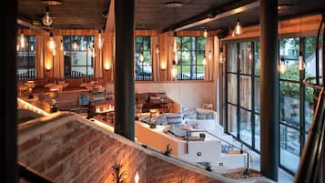 A modern interior with a fireplace, seating area, and large windows.