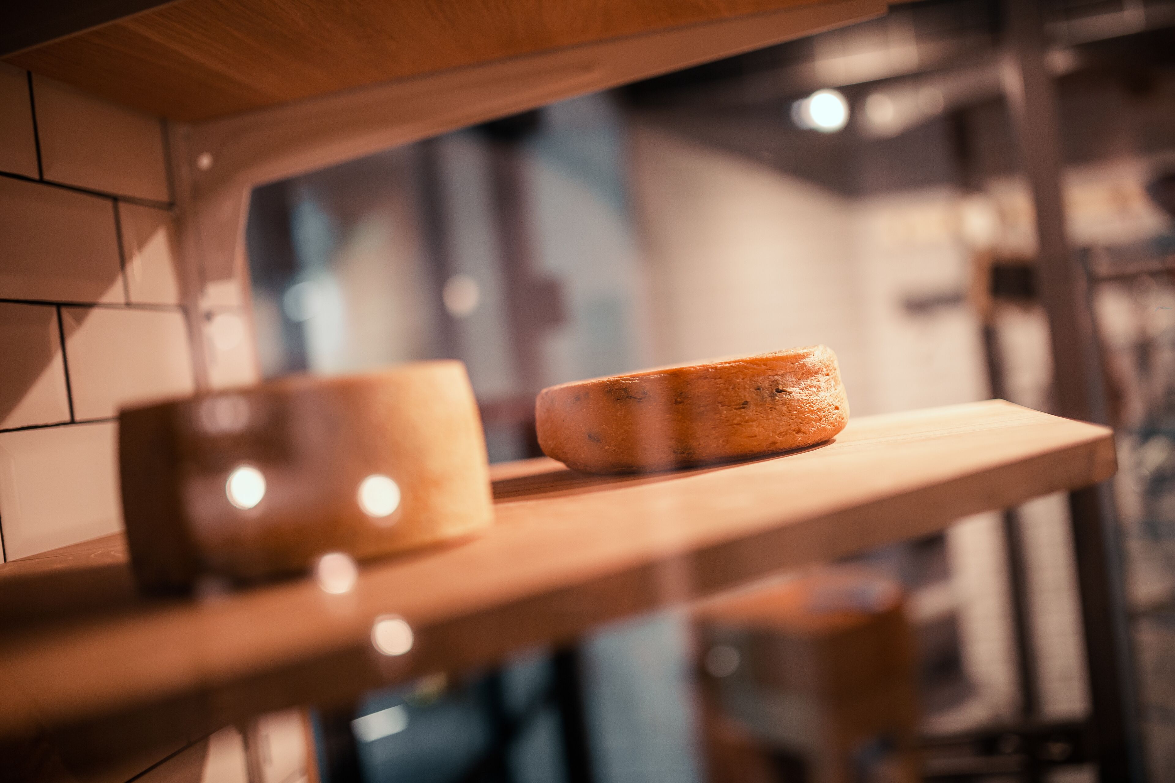 A wooden shelf with a loaf of bread and a glass jar.