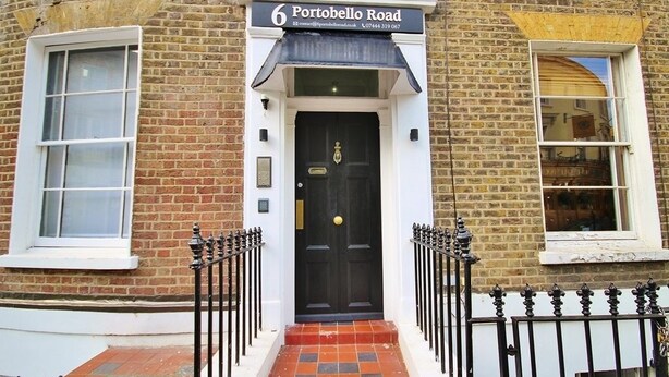 A brick building with a black door and a sign reading "Portobello Road." - 6 Portobello Road (London)