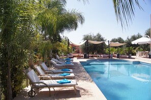 Una piscina al aire libre, tumbonas