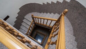 Eine Treppe mit einer Holzhandläufe und Blick auf einen Raum mit Fenster und Tür.