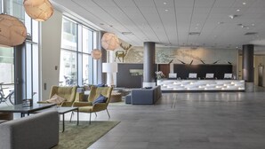 Un hall d’entrée spacieux, doté de meubles modernes, de grandes fenêtres et d’un comptoir de réception.