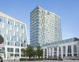 Un hotel moderno con un llamativo letrero que dice "Quality Hotel View", ventanas grandes y un diseño limpio y contemporáneo.