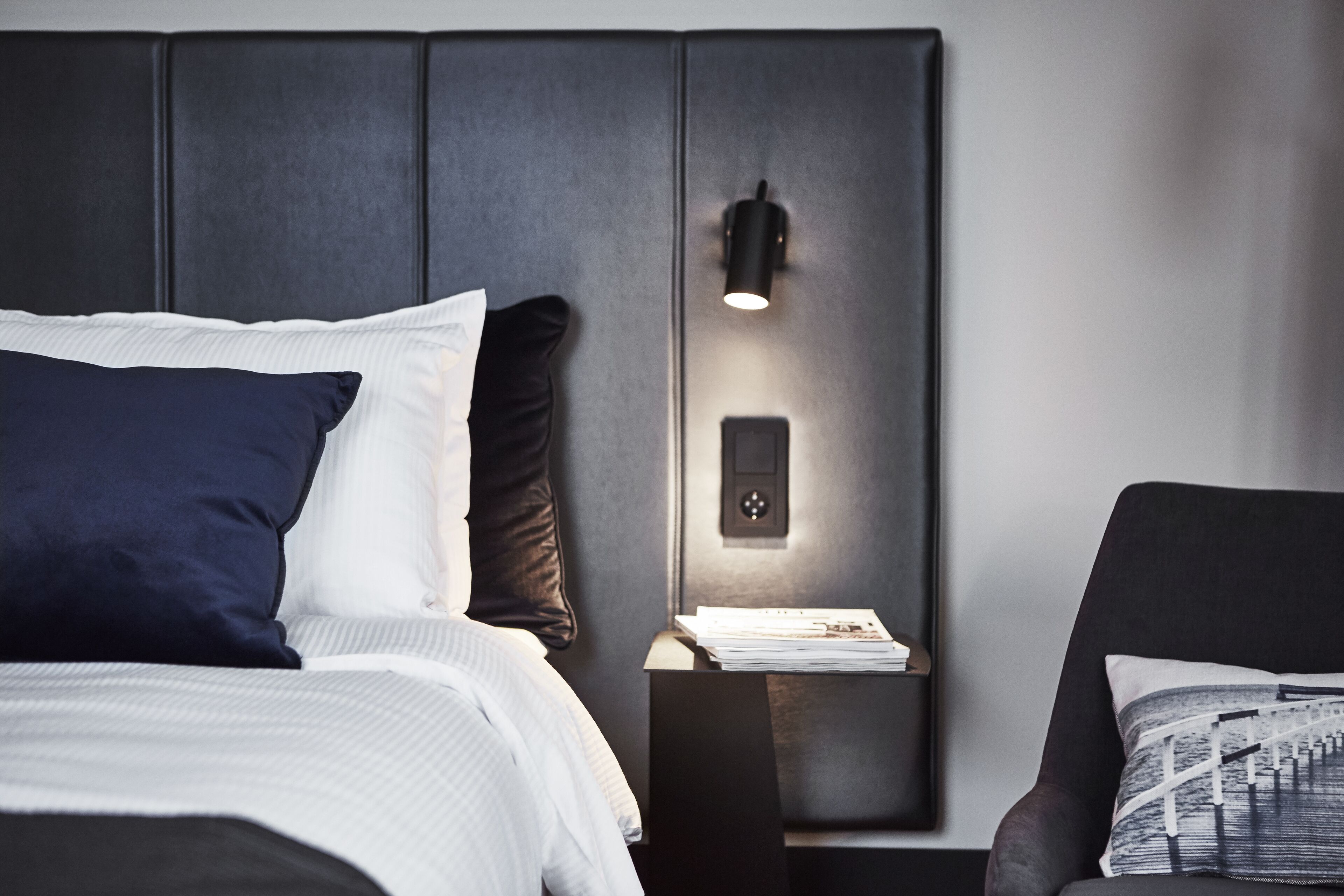 Une chambre à coucher moderne avec un lit, une table de chevet et une chaise.