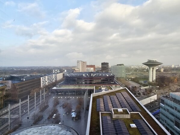 A modern building with a flat roof, solar panels, and a parking lot.