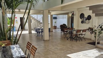 Un espacio interior amplio con una mesa de comedor, sillas y una escalera.