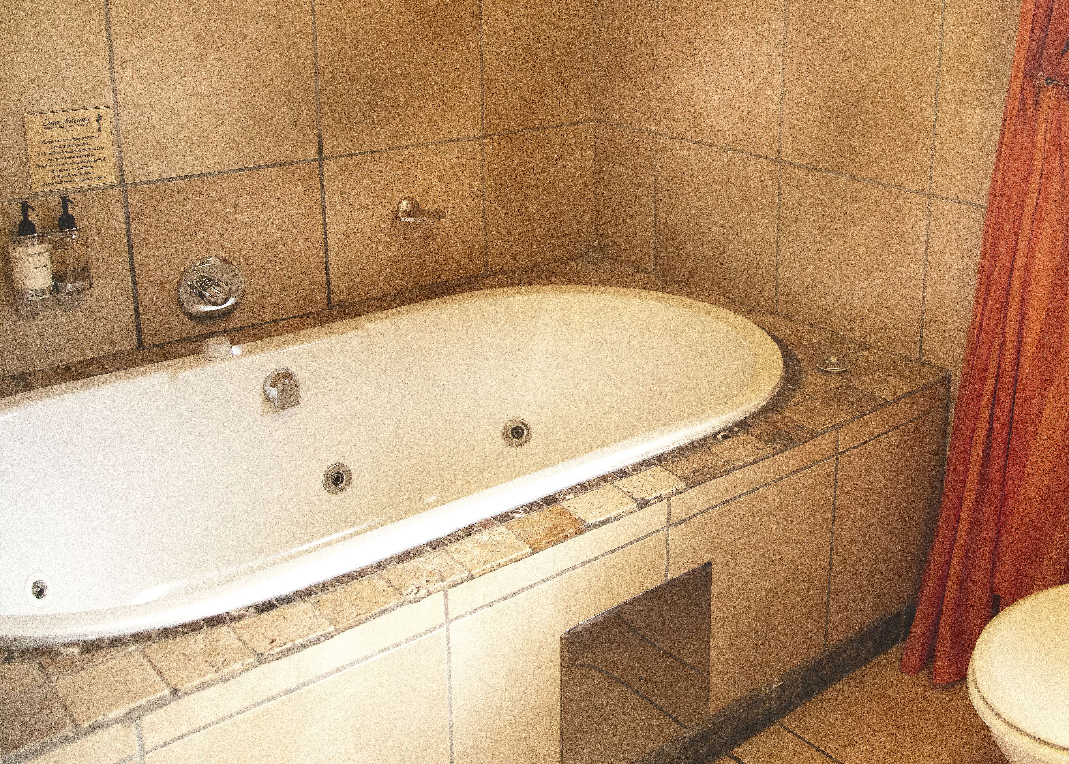 A bathroom with a bathtub, a toilet, and a shower area.