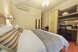 Une chambre d’hôtel avec un lit, un bureau et une chaise.