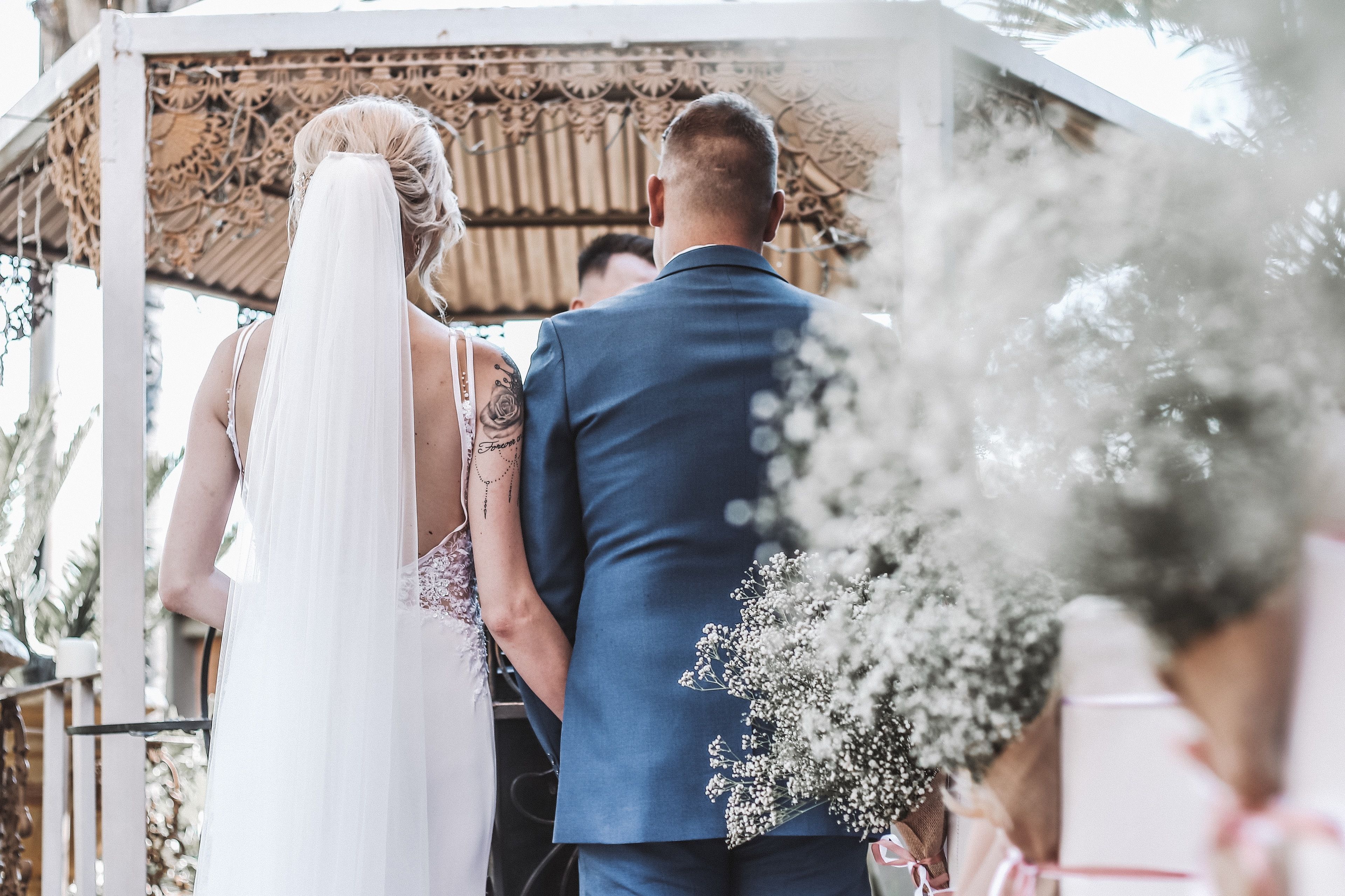 A couple holding hands at a wedding ceremony.