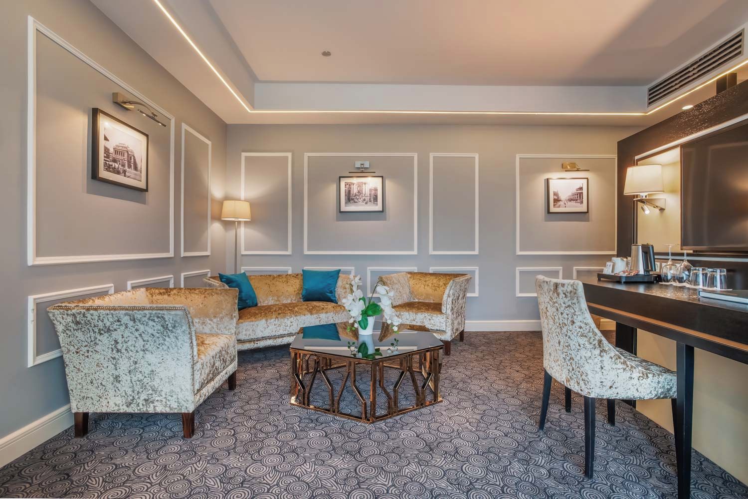 A hotel room with a sofa set, a coffee table, and a dining area.