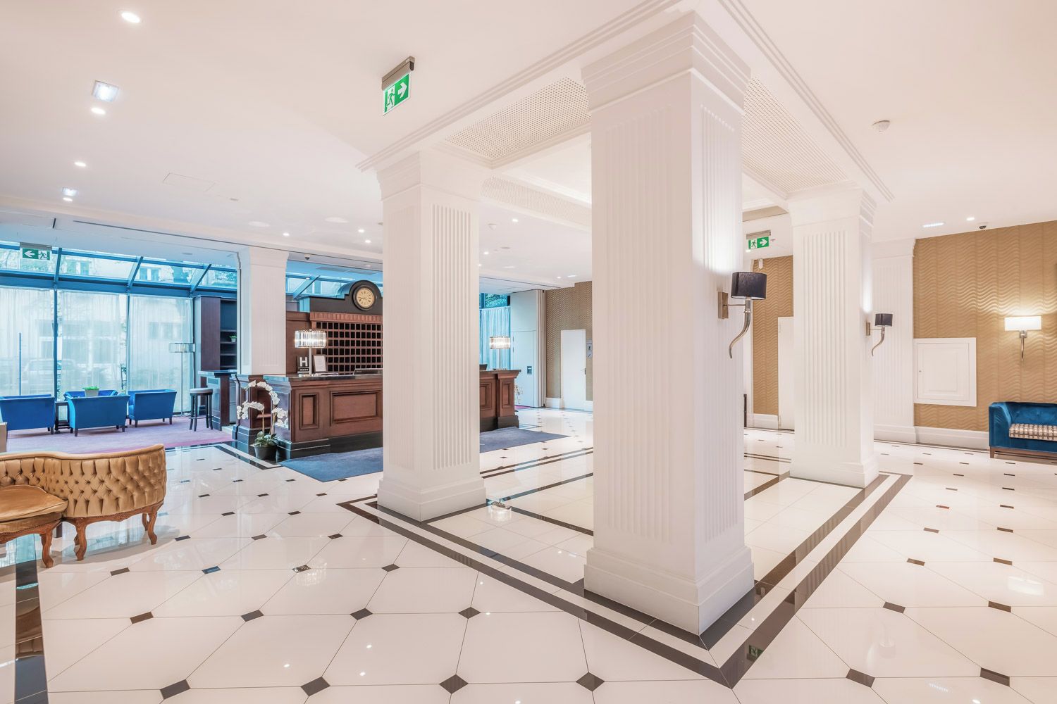 A hotel lobby with a reception desk, seating area, and a large column structure.