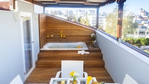 A balcony with a wooden floor, a glass table with breakfast items, a white chair, and a view of the city. - Letstay Hotel - Adult Only +12 (Antalya)