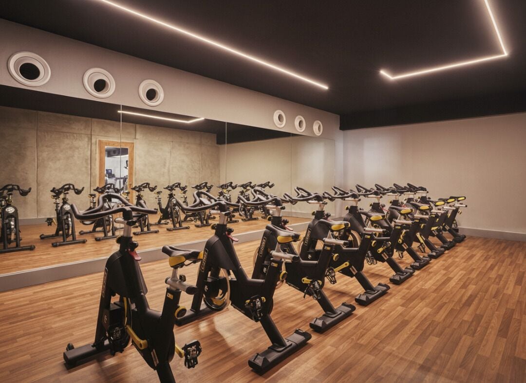 Uma academia com várias bicicletas ergométricas dispostas em fileiras.