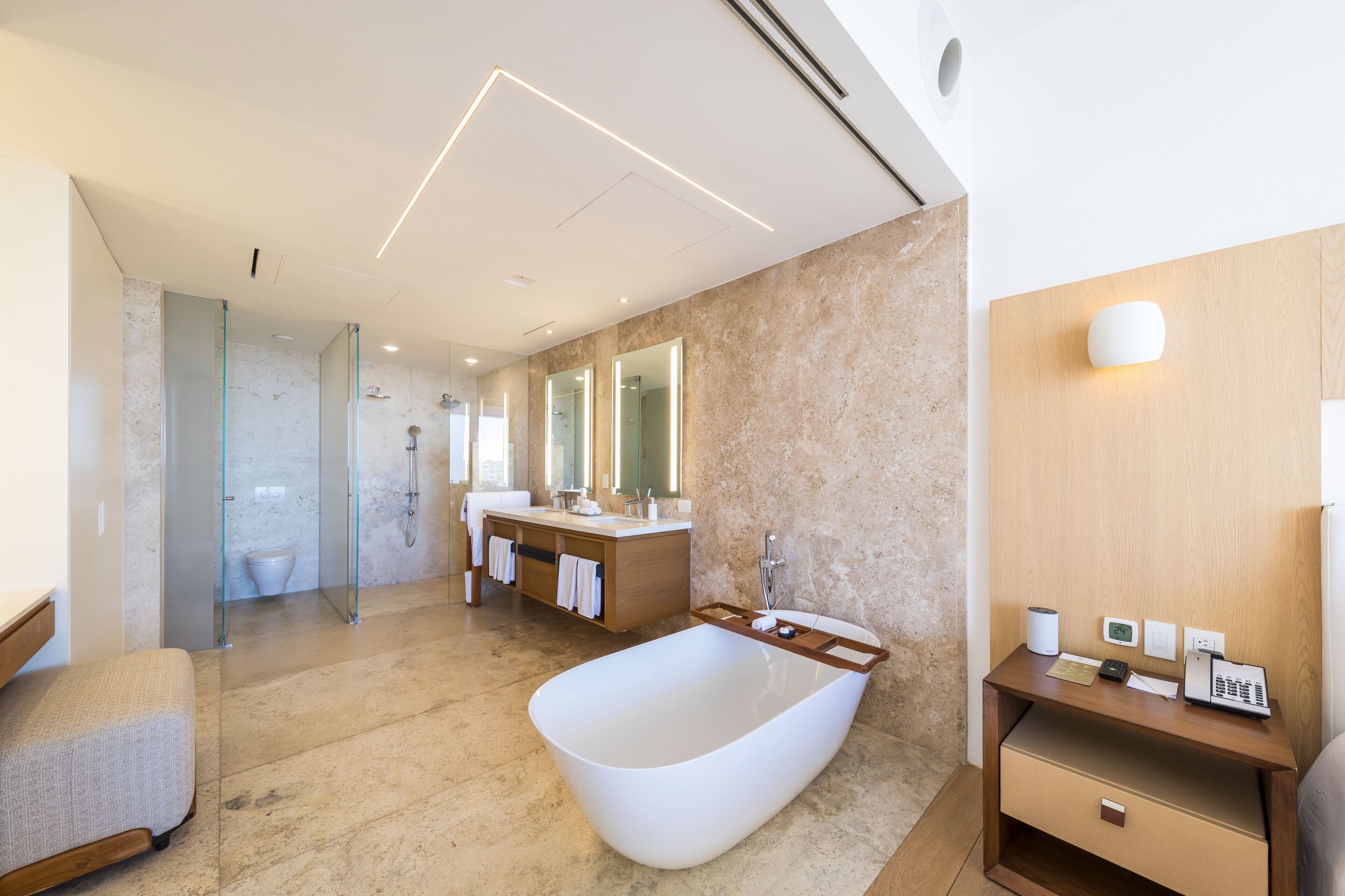 Un baño moderno con una bañera independiente, un tocador con espejo y una zona de ducha.