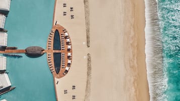 On the beach, white sand, beach cabanas, sun loungers