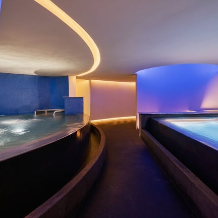 A spa area with a curved bench and a hot tub.