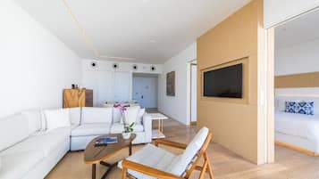 Una sala de estar moderna con sofá, mesa de centro y televisor instalado en la pared.