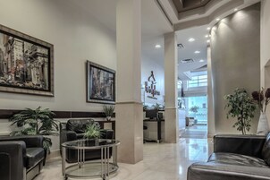A hotel lobby with leather seating, a reception desk, and artwork on the walls.
