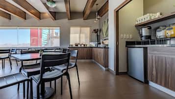 A modern kitchen with a built-in stove, a coffee machine, and a refrigerator.