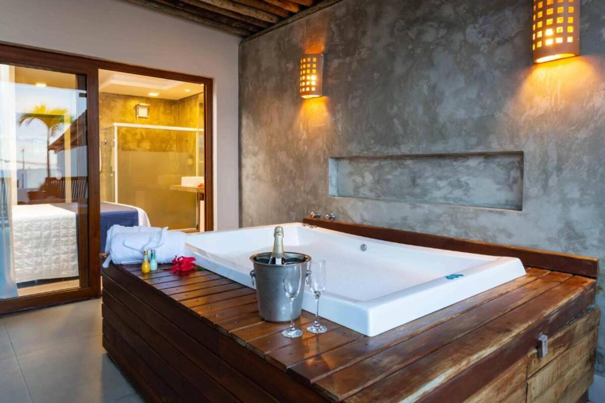 A modern bathroom with a large bathtub, a wooden vanity, and a glass shower enclosure.