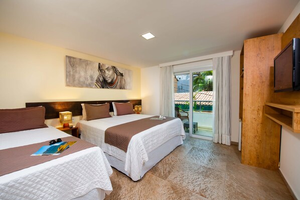 Habitación de hotel con dos camas, un cuadro en la pared, televisión y balcón con vistas.