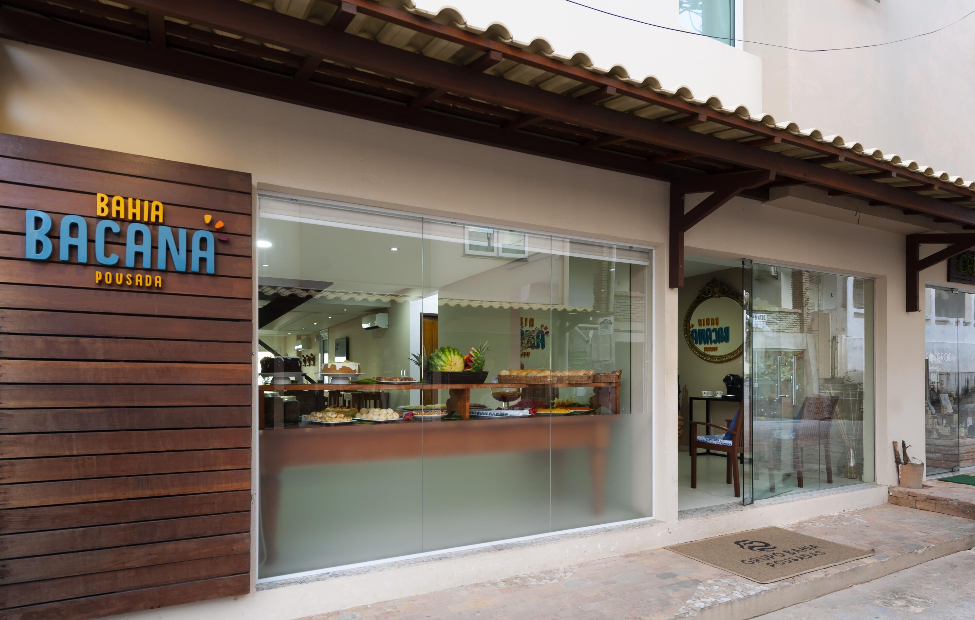 A restaurant named "Bahia Bacana" with a wooden facade and a glass entrance.