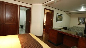 Une chambre à coucher comprenant un lit, une commode, un bureau et un canapé.