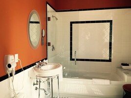 A bathroom with a white sink, mirror, and shower.