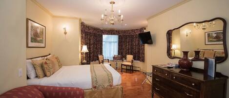 Una habitación de hotel con una cama, un tocador, un escritorio y una silla.
