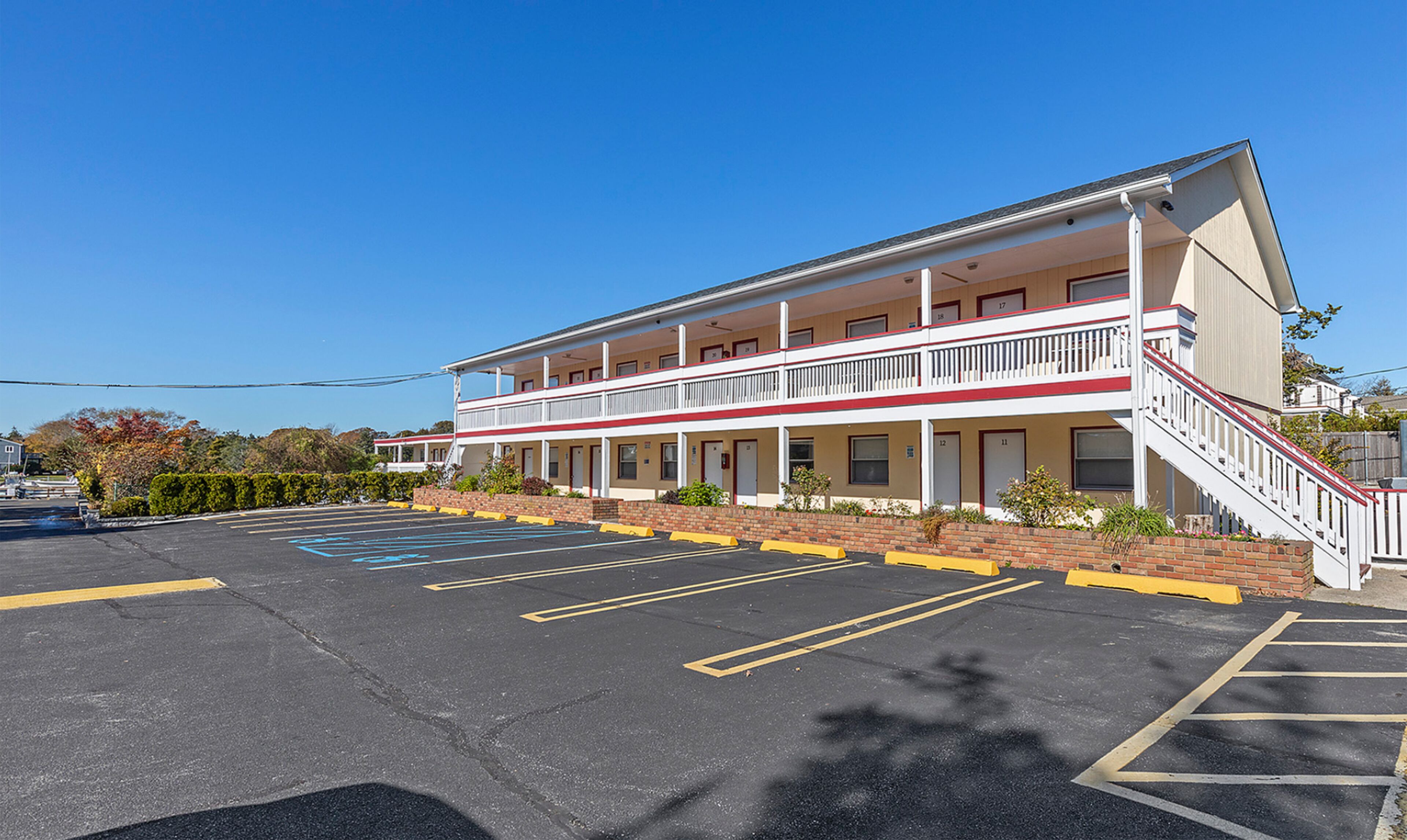 A two-story motel with a central courtyard and a parking lot.