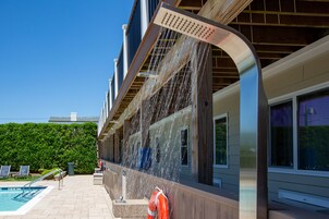 Una piscina al aire libre de temporada, sillones reclinables de piscina
