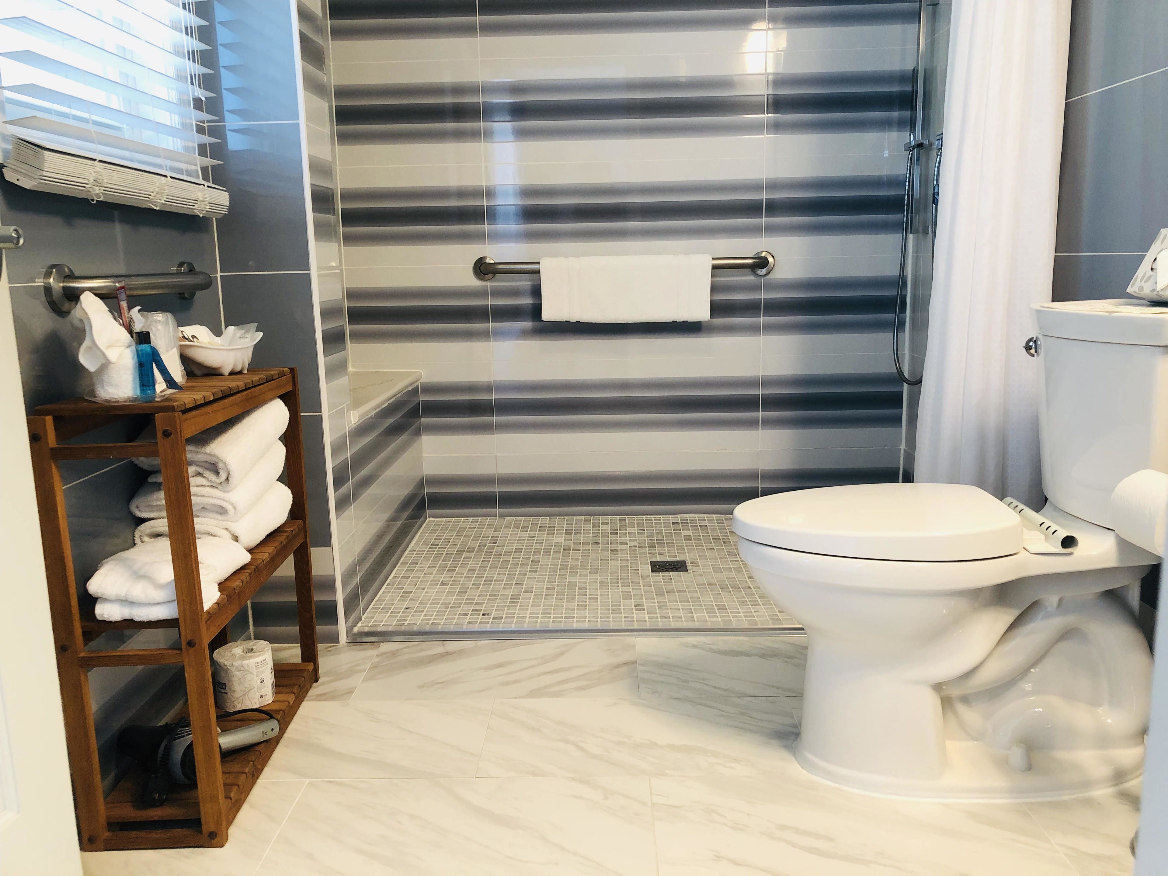 Un baño con inodoro, zona de ducha y perchero.