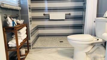 Un baño con inodoro, zona de ducha y perchero.
