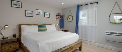 Une chambre à coucher avec un lit en bois, des tables de chevet, une lampe suspendue et une fenêtre avec des rideaux.