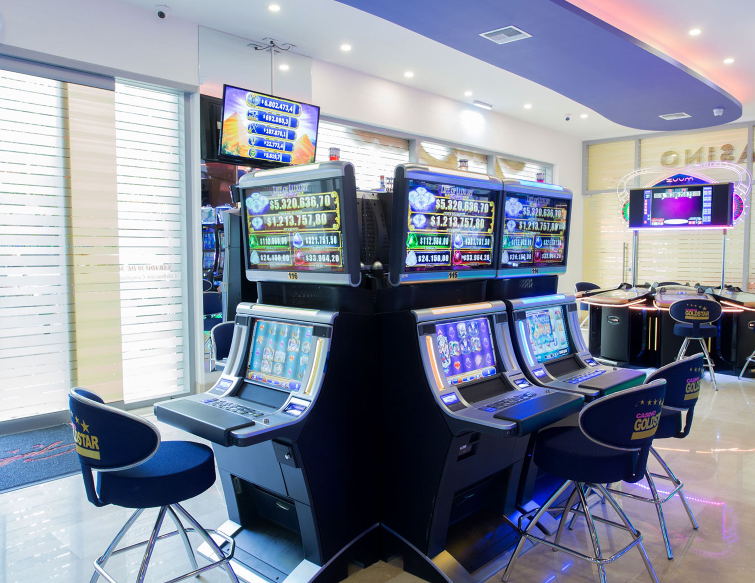 Un casino con numerosas máquinas tragamonedas y mesas de juego.