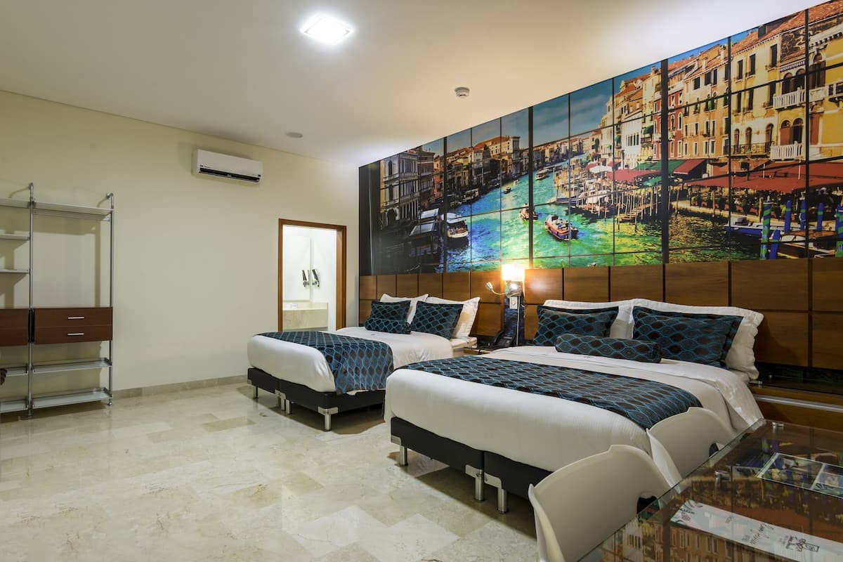 Een hotelkamer met twee bedden, een houten hoofdbord, een glazen tafel en een stadsgezicht schilderij aan de muur.
