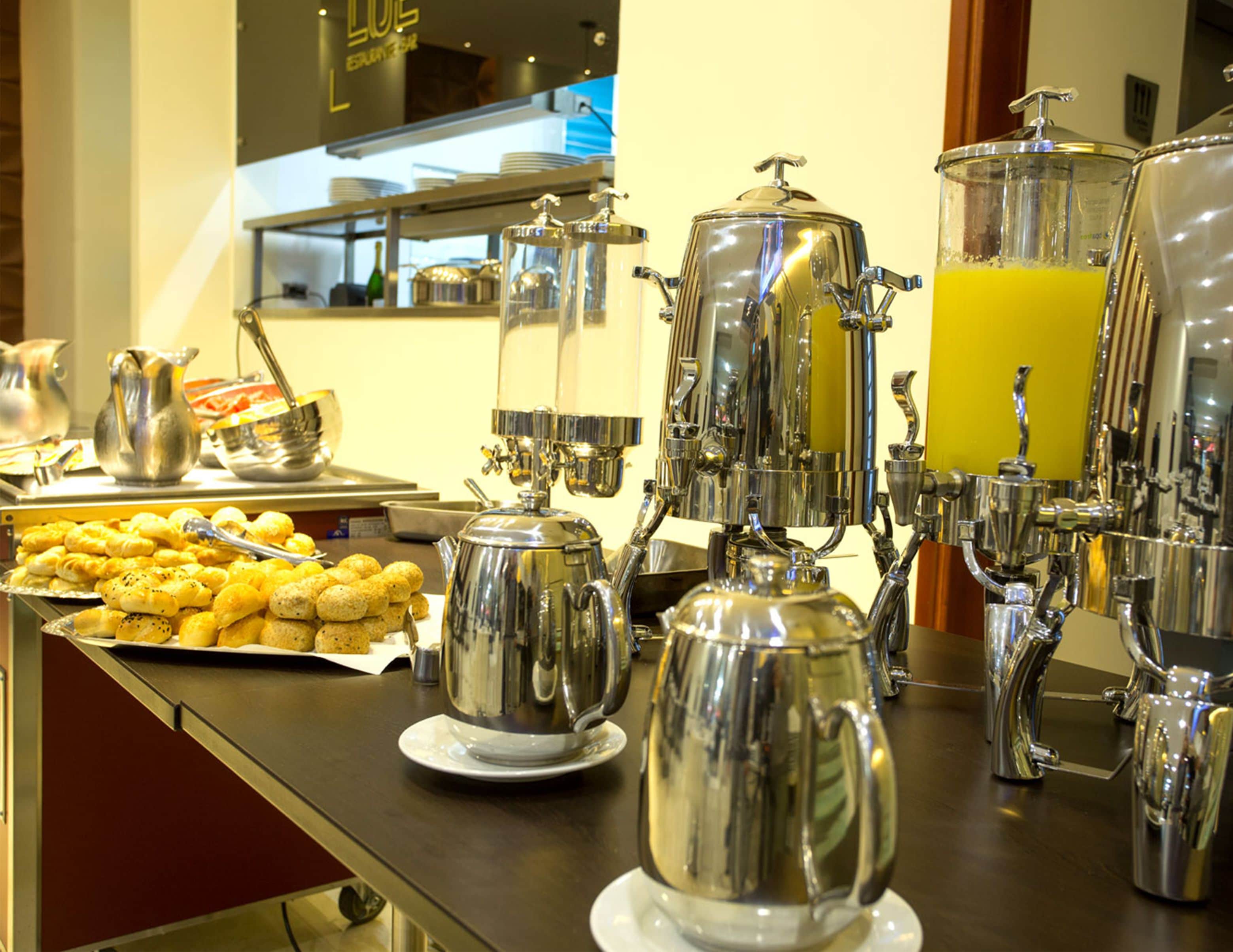 A buffet setup with various food items and beverage dispensers.