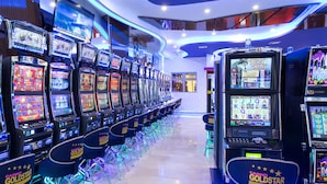 A casino with multiple slot machines and chairs arranged in rows.