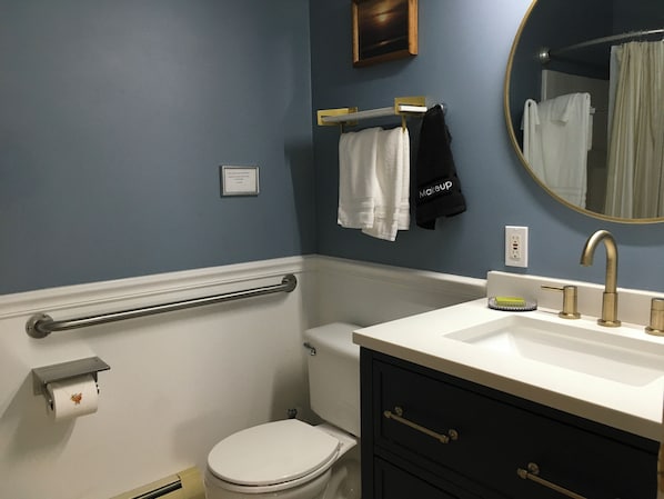 Un baño con inodoro, lavabo y barandilla.