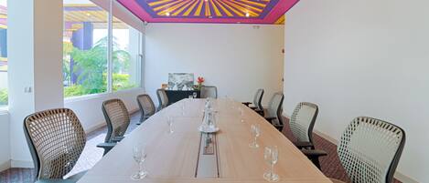 A conference room with a long table, chairs, and a colorful ceiling design.