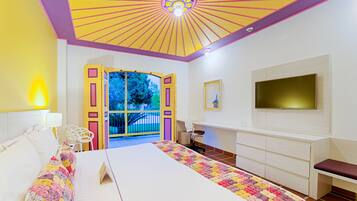 Un dormitorio con una cama grande, un escritorio, un televisor y vistas al exterior.