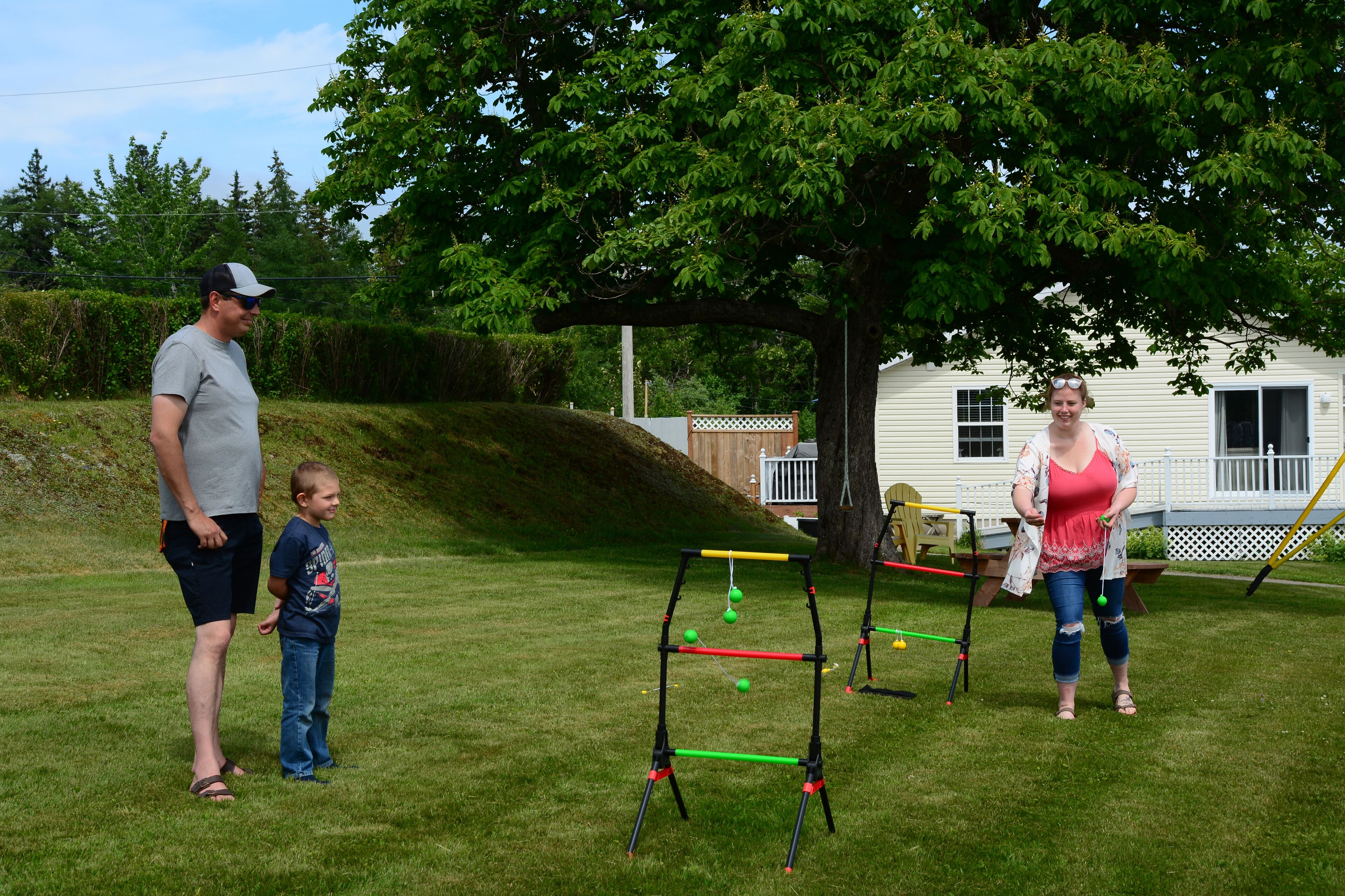 A grassy outdoor area with a swing set and a tree.