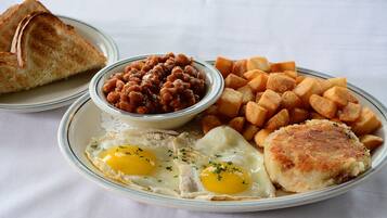 A plate with eggs, beans, hash browns, toast, and a patty.