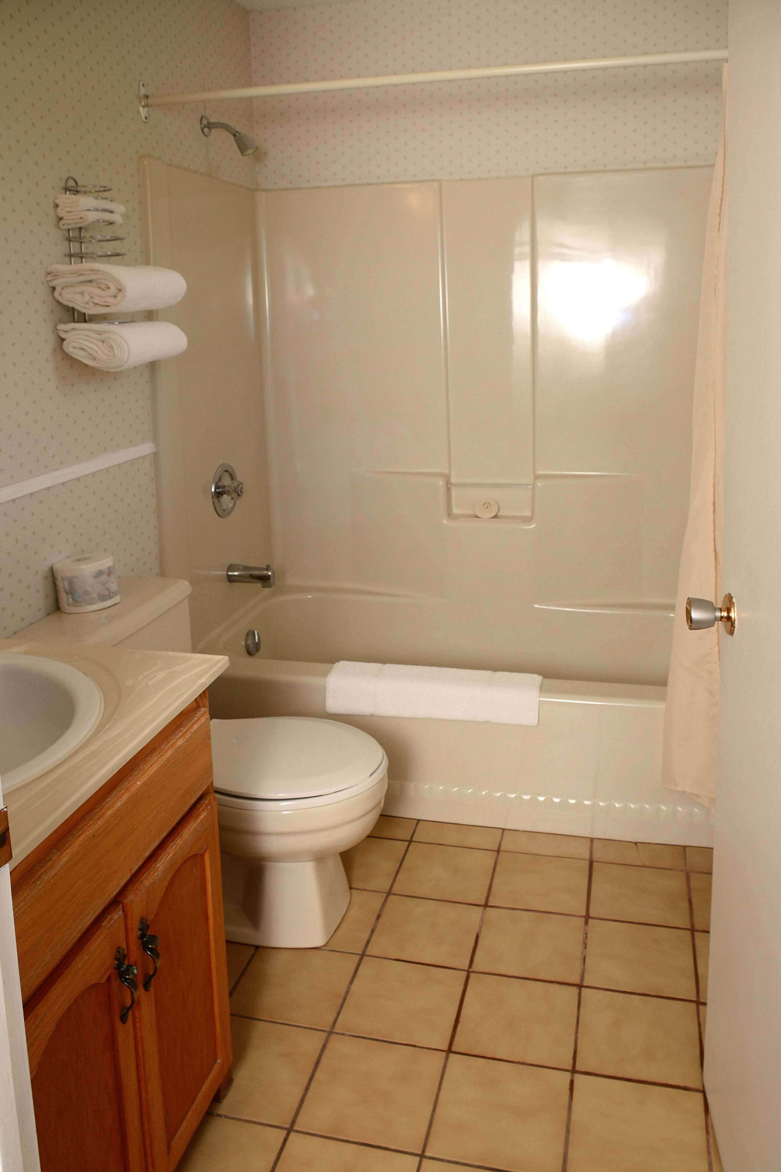 A bathroom with a toilet, sink, and bathtub.