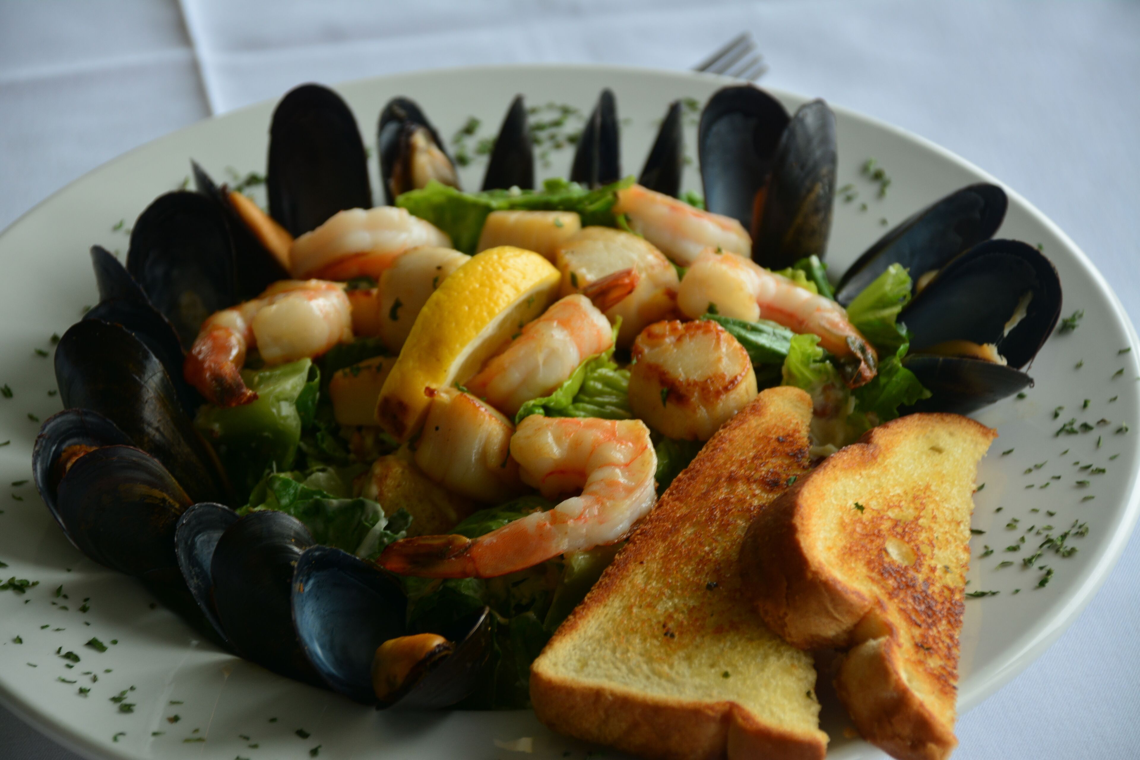 Plato con mariscos, mejillones, camarones y pan tostado.