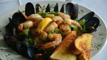 Plato con mariscos, mejillones, camarones y pan tostado.